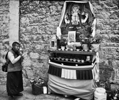 Tibetan Nun Praying at a Shrine.jpg